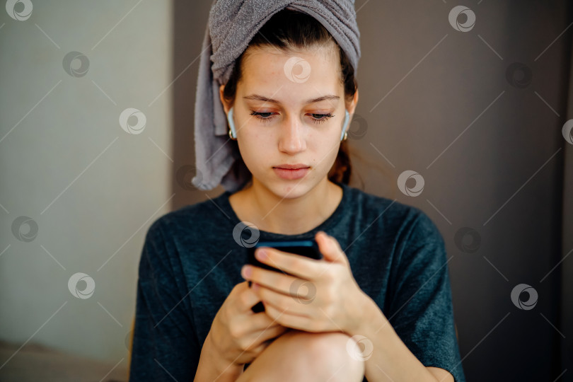 Скачать Девочка-подросток читает свой смартфон дома нейтральный портрет фотосток Ozero