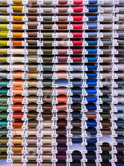 Скачать Разноцветные катушки с нитками в ряд, фон для шитья фотосток Ozero