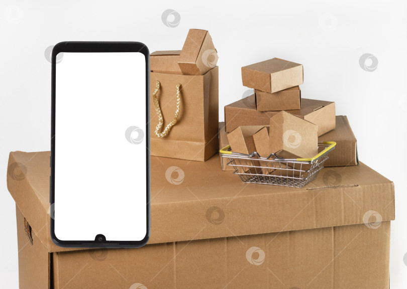 Скачать Картонные коробки разных размеров и смартфон с изолированным экраном на белом фоне. Доставка с торговых площадок, интернет-магазинов. фотосток Ozero