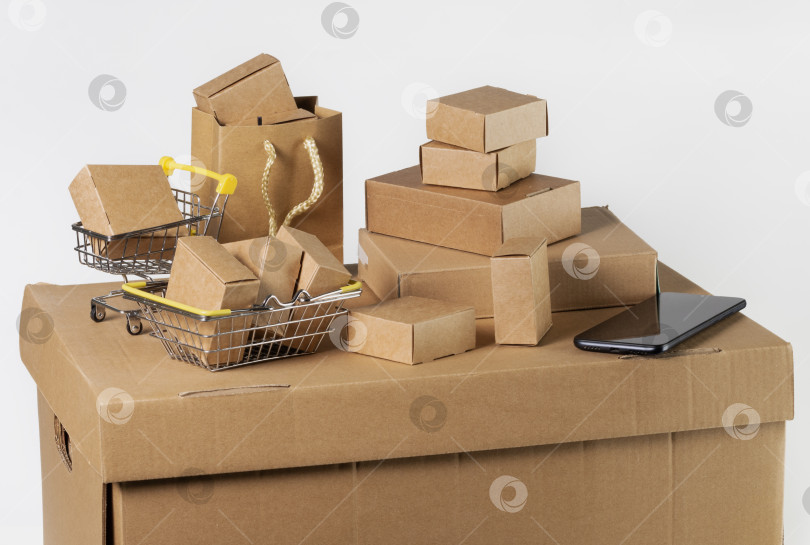 Скачать Картонные коробки разных размеров, корзины, пакеты и смартфон на белом фоне. Доставка с торговых площадок и интернет-магазинов фотосток Ozero