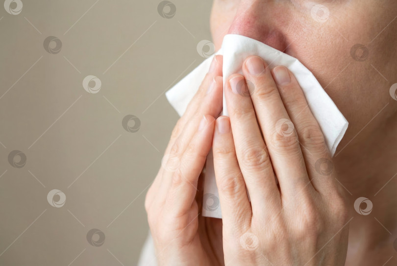 Скачать Человек, чихающий с помощью салфетки, вызывает аллергию или простуду с насморком. Создан искусственный интеллект. фотосток Ozero