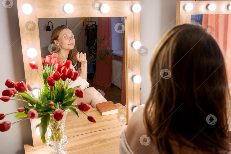 Скачать Отражение женщины в Голливудском зеркале с тюльпанами и книгой фотосток Ozero