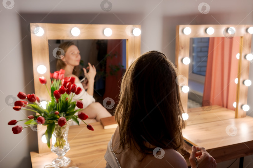 Скачать Женщина, указывающая на Двойное Голливудское зеркало с красными тюльпанами фотосток Ozero