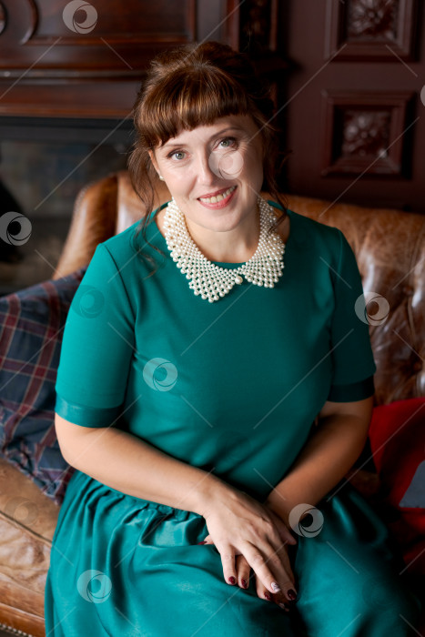 Скачать Лучезарная Зрелая женщина, доброжелательно улыбающаяся в классическом домашнем интерьере фотосток Ozero