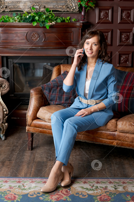 Скачать Профессиональная деловая женщина Улыбается во время разговора по телефону в классическом офисе фотосток Ozero