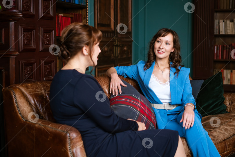 Скачать Внимательная деловая женщина в синем костюме слушает партнера в классическом офисе фотосток Ozero