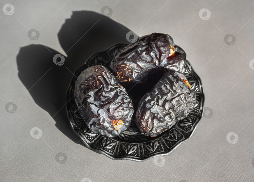 Скачать В богато украшенной чаше лежат три темных сморщенных финика Аджва фотосток Ozero