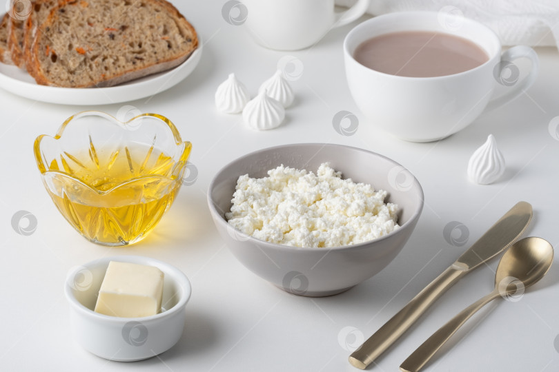 Скачать Завтрак с творогом, медом, какао и выпечкой на столе фотосток Ozero