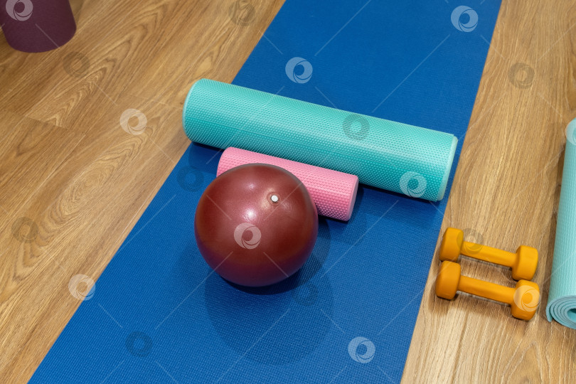 Скачать Тренажеры, разложенные на коврике в фитнес-зале для занятий спортом и тренировок в домашних условиях фотосток Ozero