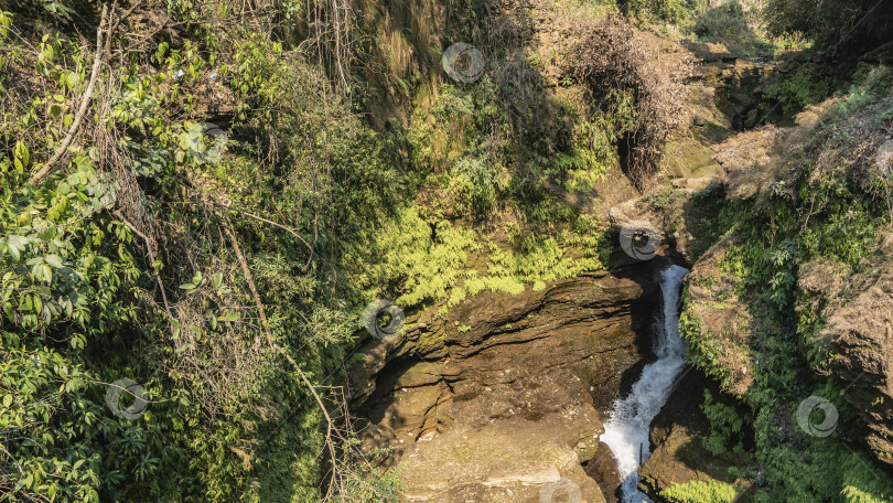 Скачать Живописный водопад. По ущелью течет поток белой воды фотосток Ozero