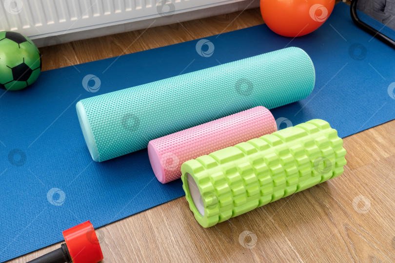Скачать Различные виды поролоновых роликов и оборудования на синем коврике для упражнений в тренажерном зале дома фотосток Ozero