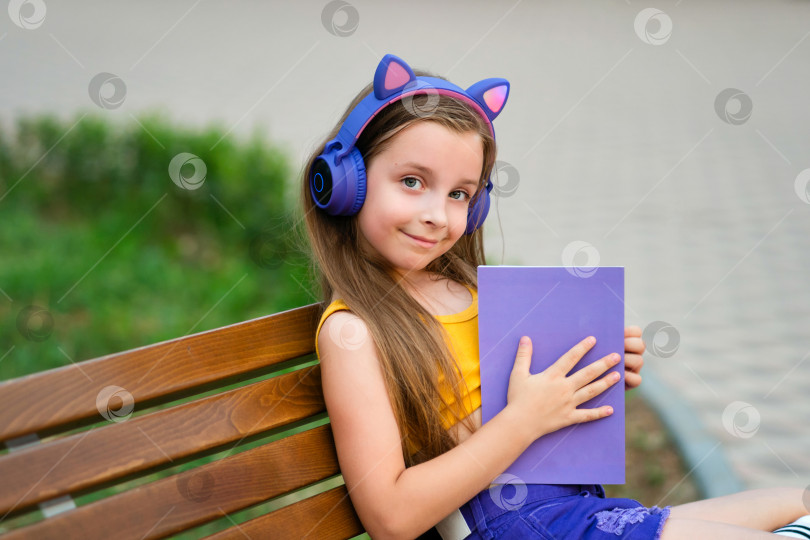 Скачать Девочка-подросток с книгой на скамейке в парке фотосток Ozero