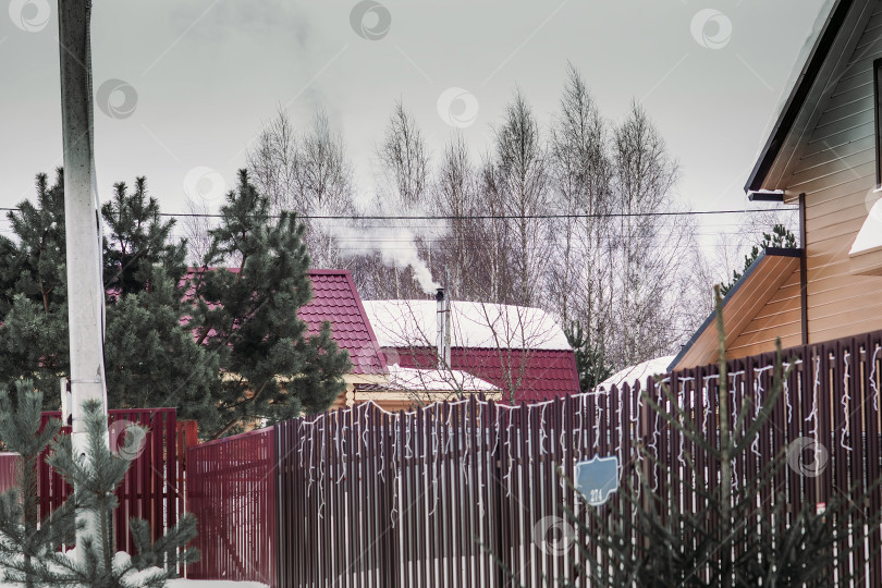 Скачать Рождественская елка у металлического забора в деревне фотосток Ozero