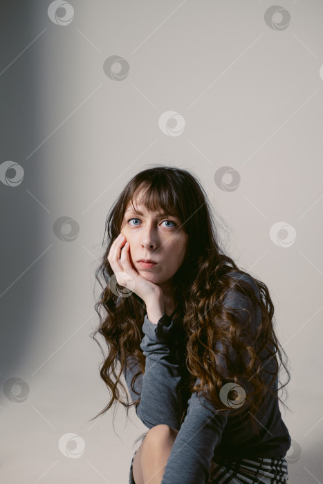 Скачать Портрет молодой женщины с длинными волнистыми волосами и голубыми глазами на циклораме. Женская фотосессия фотосток Ozero