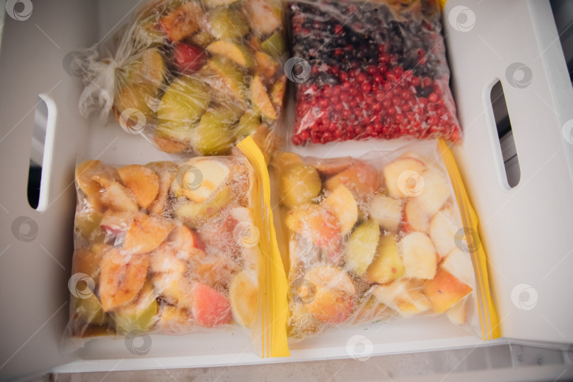 Скачать Фрукты и ягоды упаковывают в полиэтиленовые пакеты и хранят в морозильной камере. Свежие и полезные продукты в любое время года. фотосток Ozero