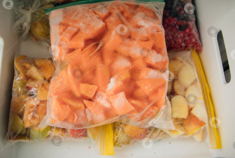 Скачать Фрукты и ягоды упаковывают в полиэтиленовые пакеты и хранят в морозильной камере. Свежие и полезные продукты в любое время года. фотосток Ozero