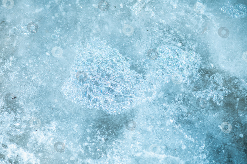 Скачать Замерзшая водная гладь с нежными узорами из ледяных кристаллов и полупрозрачными голубыми текстурами - безмятежное зимнее макро-исследование мороза, света, чистоты и хрупкой природной геометрии. фотосток Ozero