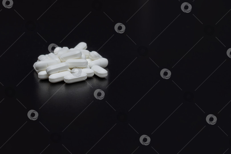 Скачать Белые таблетки на черном столе фотосток Ozero