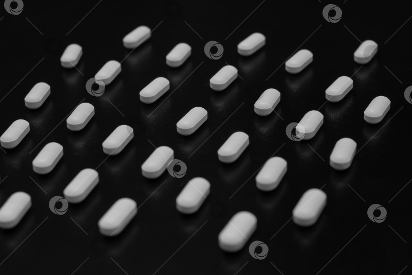 Скачать Белые таблетки на черном фоне фотосток Ozero