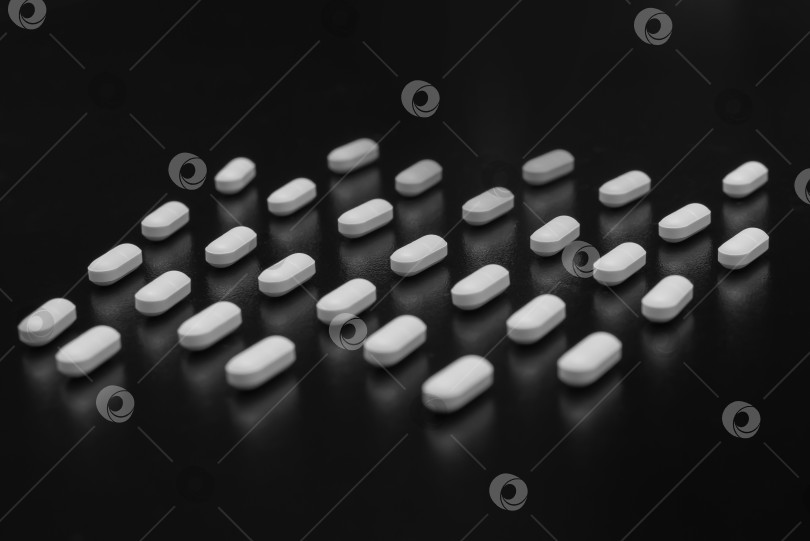 Скачать Белые таблетки на черном фоне фотосток Ozero