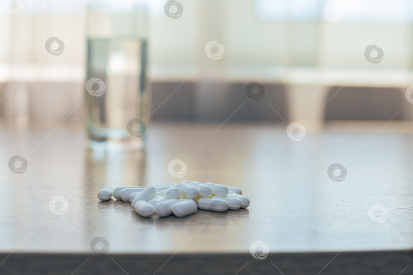 Скачать Таблетки, медикаменты и стакан воды на деревянном столе фотосток Ozero