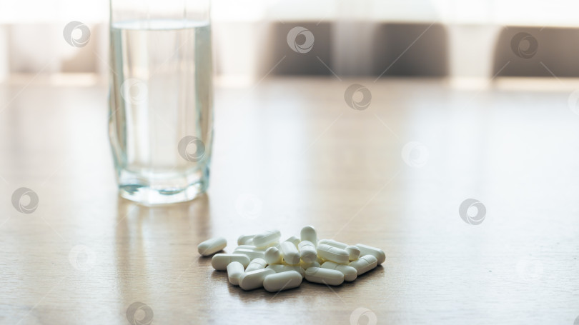 Скачать Таблетки, медикаменты и стакан воды на деревянном столе фотосток Ozero
