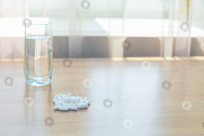 Скачать Таблетки, медикаменты и стакан воды на деревянном столе фотосток Ozero