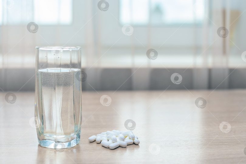 Скачать Таблетки, медикаменты и стакан воды на деревянном столе фотосток Ozero