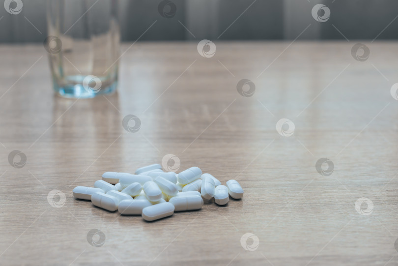Скачать Таблетки, медикаменты и стакан воды на деревянном столе фотосток Ozero