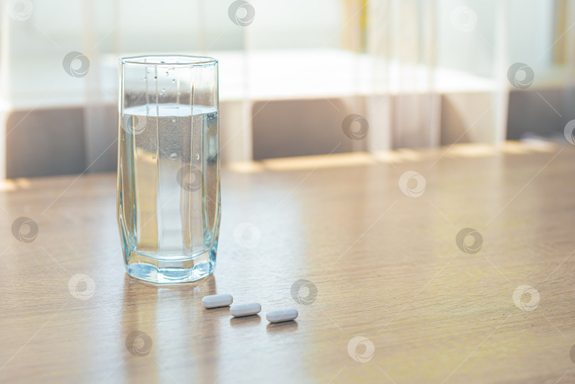 Скачать Таблетки, медикаменты и стакан воды на деревянном столе фотосток Ozero