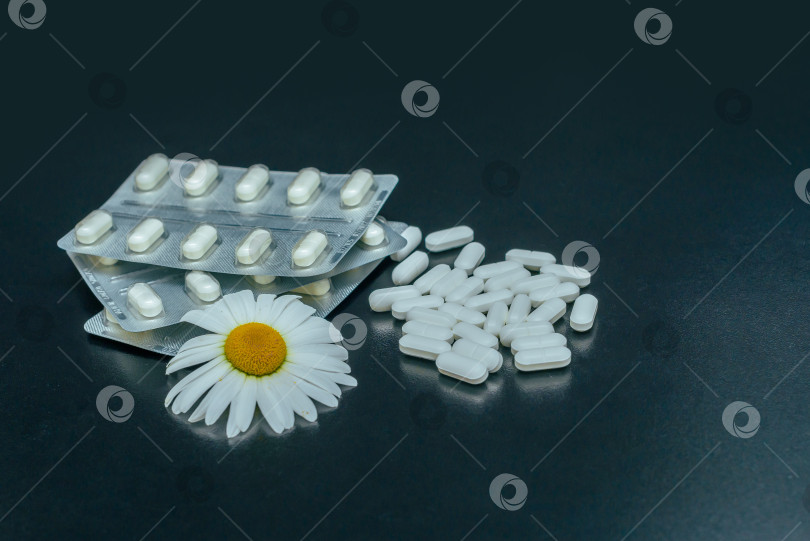 Скачать Таблетки и цветок ромашки на темном фоне фотосток Ozero