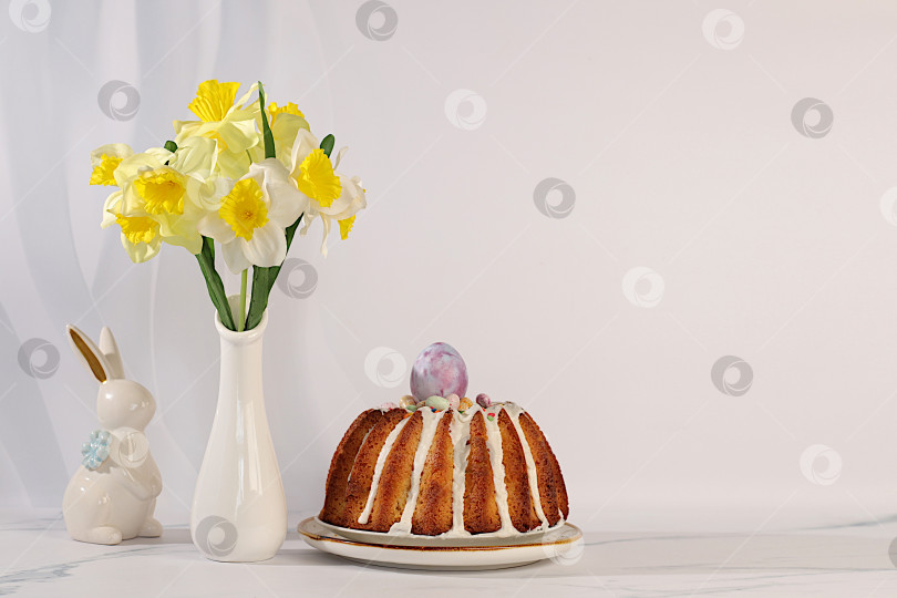 Скачать Концепция празднования Пасхи, традиционный пасхальный кулич, фигурки пасхальных кроликов и весенние нарциссы в вазе на фоне элегантной кухни, идеи пасхальных блюд для домашней кухни, шаблон дизайна фотосток Ozero