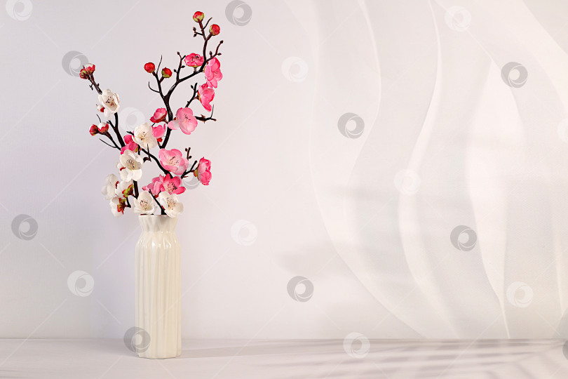 Скачать Элегантный солнечный красочный баннер с розовыми цветущими ветками сакуры в вазе, абстрактная весенняя цветочная композиция и шаблон для вашего творчества, демонстрационный стол и весенняя концепция, фотосток Ozero