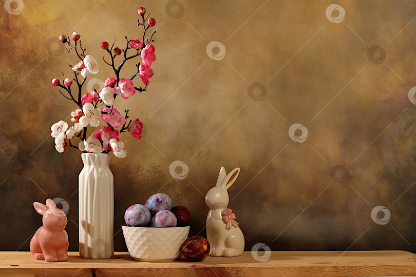 Скачать Концепция празднования Пасхи, крашеные яйца, фигурки пасхальных кроликов и ветки сакуры в вазе на фоне элегантной кухни, идеи пасхальных блюд для домашней кухни, шаблон дизайна фотосток Ozero
