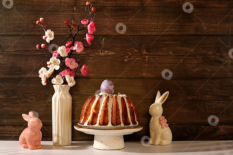Скачать Концепция празднования Пасхи, традиционный пасхальный кулич, фигурки пасхальных кроликов и ветки сакуры в вазе на фоне элегантной кухни, идеи пасхальных блюд для домашней кухни, шаблон дизайна фотосток Ozero