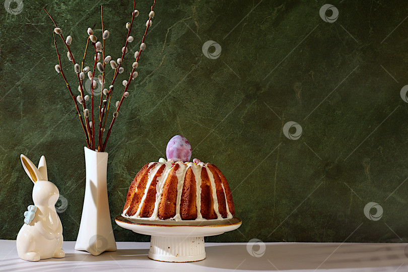 Скачать Традиционный пасхальный кулич, фигурки пасхальных кроликов и веточки вербы в вазе на фоне элегантной кухни, концепция празднования Пасхи, идеи пасхальных блюд для домашней кухни, шаблон дизайна фотосток Ozero