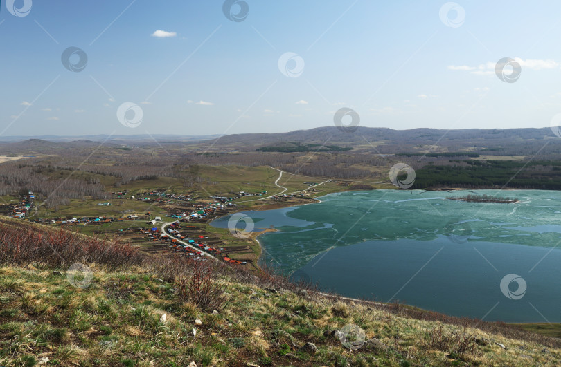 Скачать Маленькая башкирская деревня (Россия) на берегу озера с тающим льдом фотосток Ozero