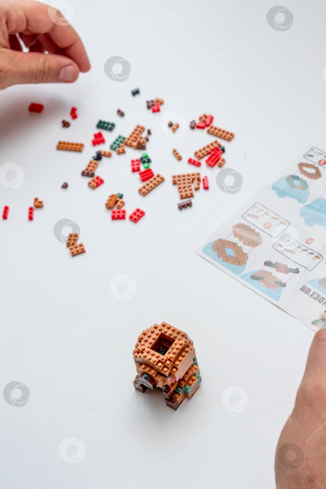 Скачать Бар, Черногория, 20 марта 2026 года, Мужчина играет в конструктор Lego фигуркой животного капибары фотосток Ozero