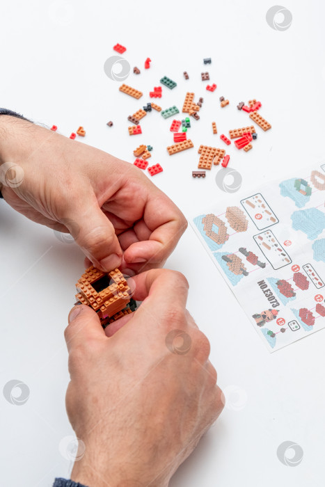 Скачать Бар, Черногория, 20 марта 2026 года, Мужчина играет в конструктор Lego с фигуркой животного капибары фотосток Ozero