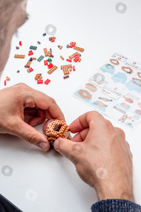 Скачать Бар, Черногория, 20 марта 2026 года, Мужчина играет в конструктор Lego с фигуркой животного капибары фотосток Ozero