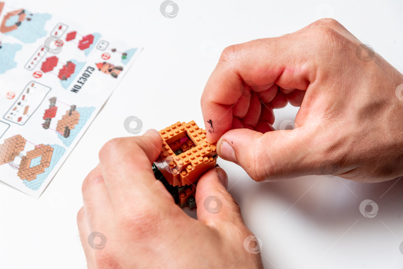 Скачать Бар, Черногория, 20 марта 2026 года, Мужчина играет в конструктор Lego с фигуркой животного капибары фотосток Ozero