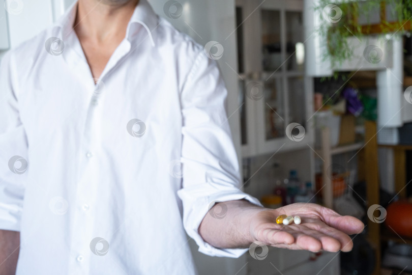 Скачать Мужчина принимает витамины, мужское здоровье, биологически активные добавки для мужчин, повышение иммунитета, витамины для придания энергии, реклама витаминных брендов, промо-акция в аптеке фотосток Ozero