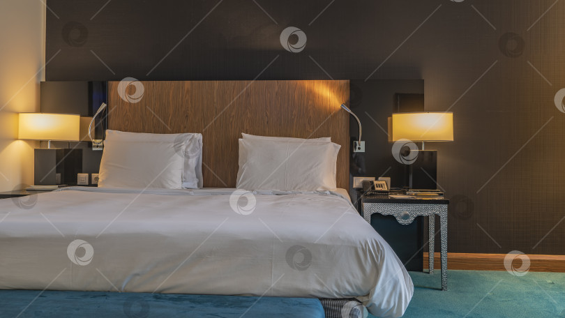 Скачать Двуспальная кровать застелена белыми простынями. В изголовье кровати подушки. фотосток Ozero