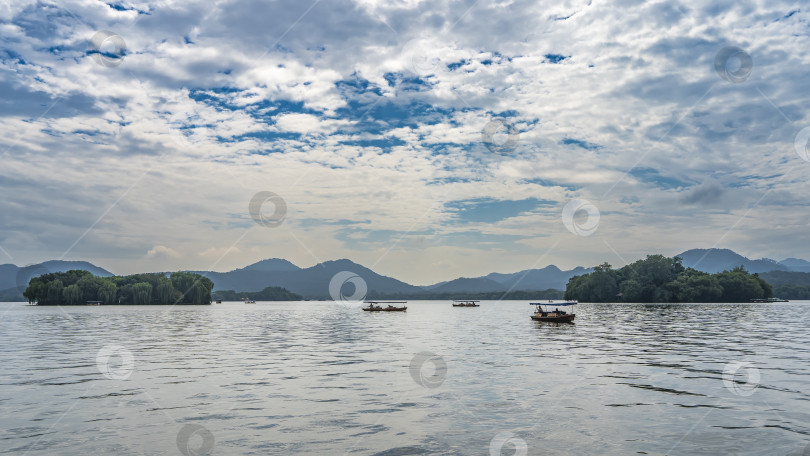 Скачать По спокойному и красивому озеру плывут туристические лодки. фотосток Ozero