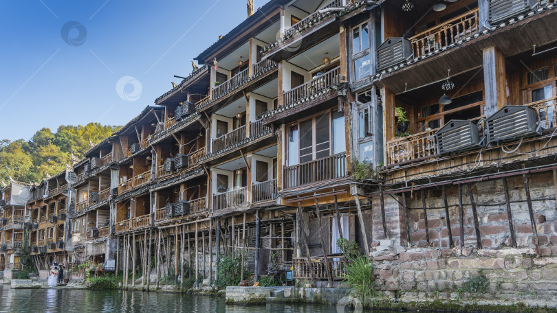 Скачать Древний китайский городок Фэнхуан. Старинные здания на деревянных сваях у реки. фотосток Ozero