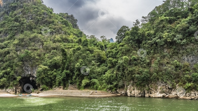 Скачать Живописная река. В прибрежной скале есть пещера. фотосток Ozero
