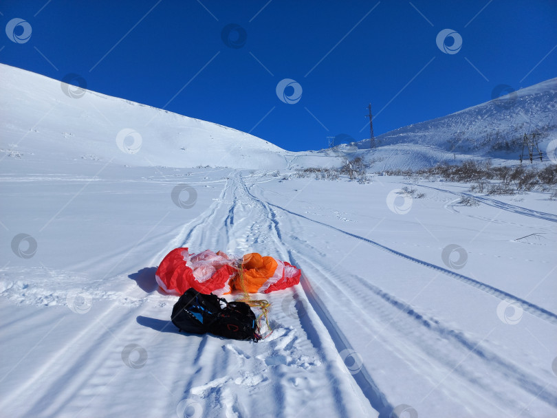 Скачать Параплан и подвеска на снегу во время подъема в гору к месту старта. фотосток Ozero