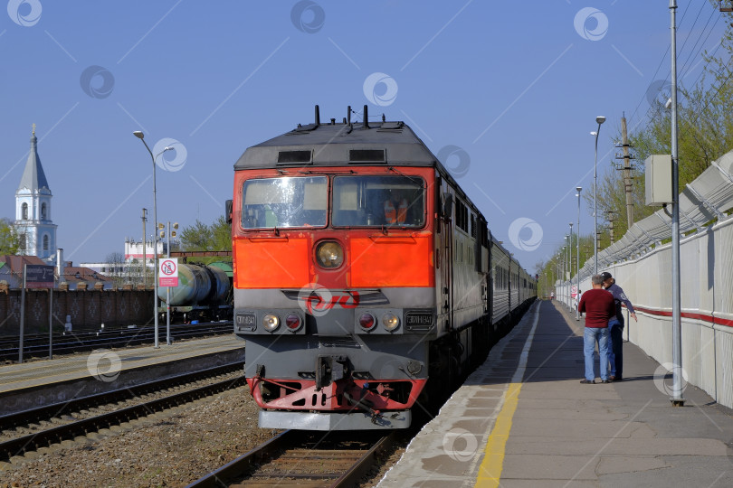 Скачать Пассажирский поезд прибывает на станцию назначения. Люди в ожидании на перроне. фотосток Ozero