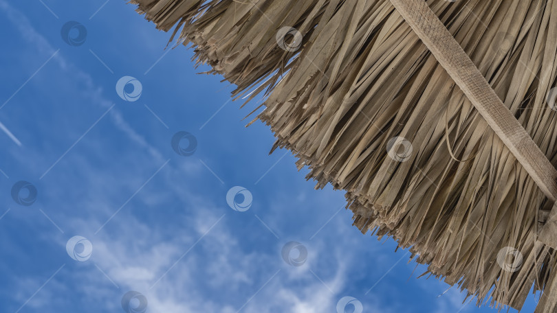 Скачать Фрагмент солнечного зонта на фоне голубого неба и облаков. фотосток Ozero