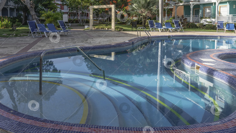 Скачать Бассейн имеет причудливую округлую форму. Дно выложено голубой плиткой. фотосток Ozero